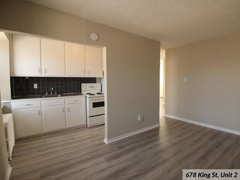 A kitchen with white cabinets and a black tile backsplash.