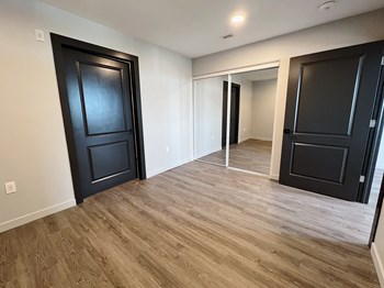 Bedroom with hardwood floors and mirrored closet doors - Photo Gallery 8