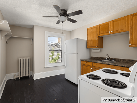 a kitchen with a stove refrigerator and a ceiling fan