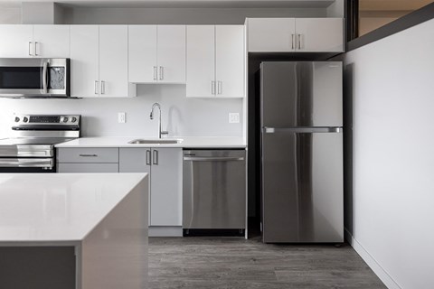 a modern kitchen with stainless steel appliances and white cabinets