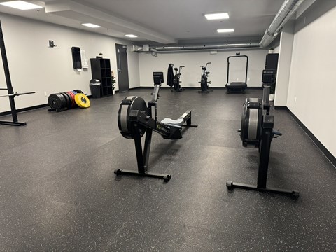 a gym with weights and other exercise equipment on the floor