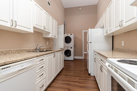 A kitchen with white cabinets and appliances.