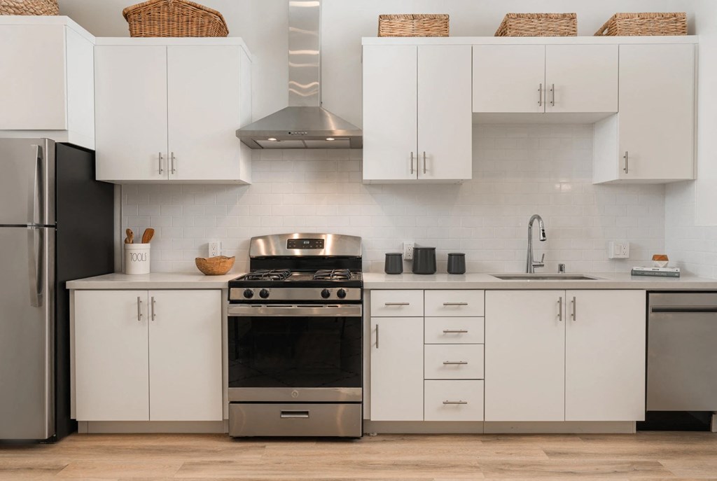 a white kitchen with stainless steel appliances and white cabinets