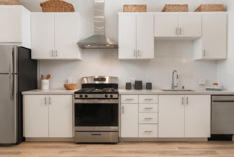 A modern kitchen with white cabinets and stainless steel appliances.