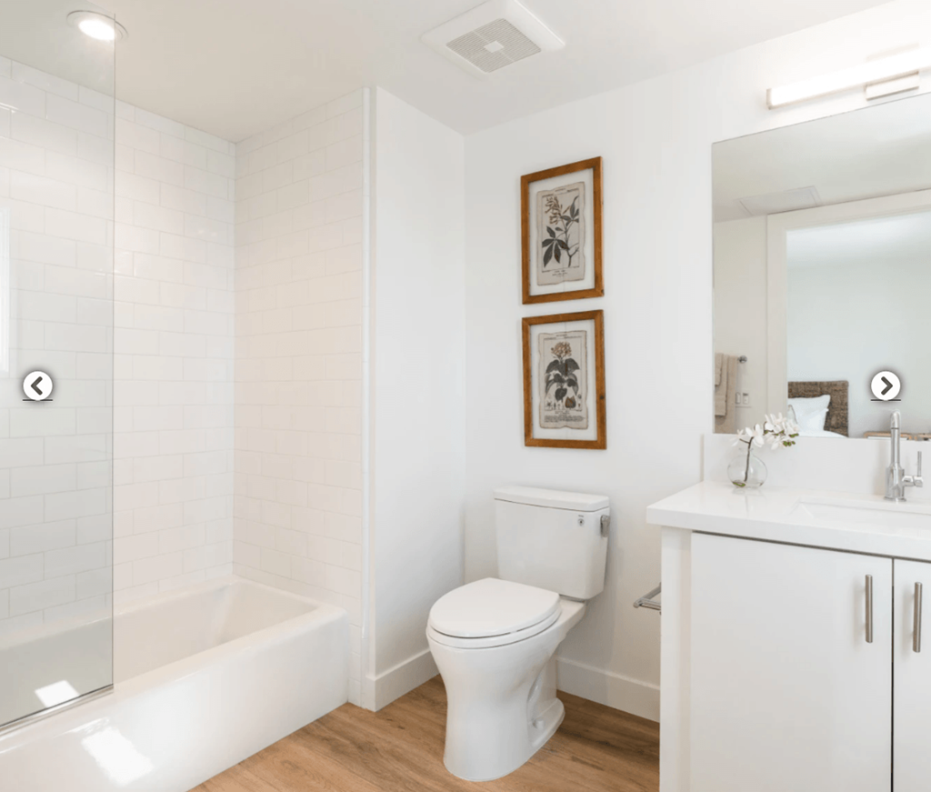 a white bathroom with a toilet and a bath tub