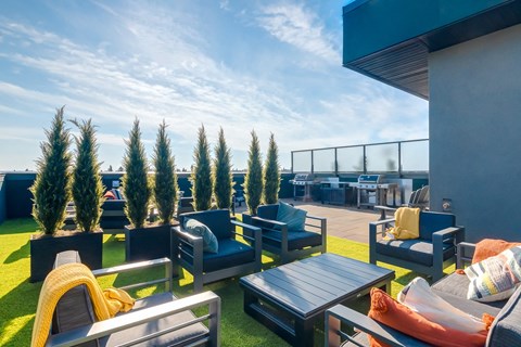 A sunny day at the rooftop with blue chairs and tables.