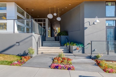 A modern building with a wooden ceiling and a staircase leading to the entrance.