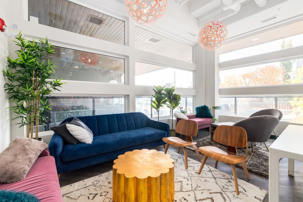 A living room with a blue couch and wooden chairs.