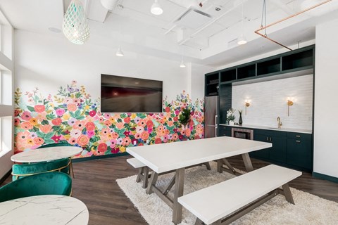 A dining room with a white table and a green chair.