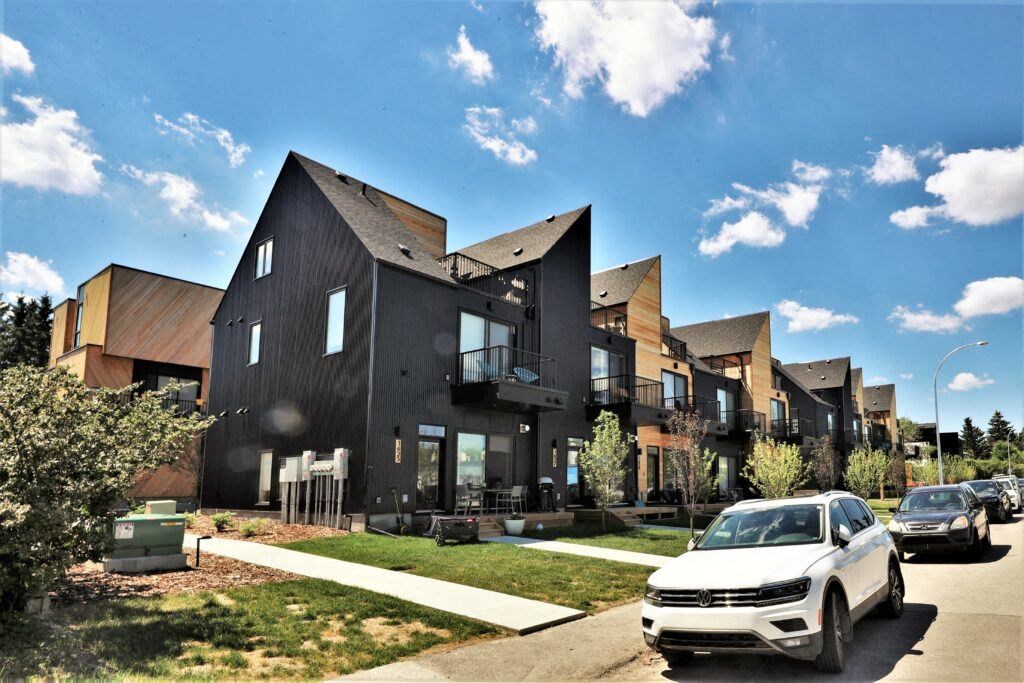 a row of houses with cars parked in front of them