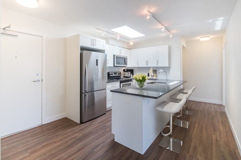a kitchen with a island and a stainless steel refrigerator