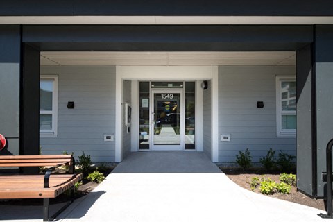 a view of the front of the building with the doors open and a bench in front of
