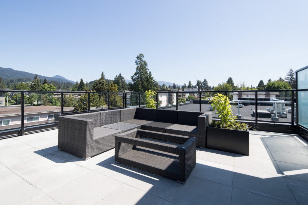 a seating area on the roof of a building with a view of the mountains in the background