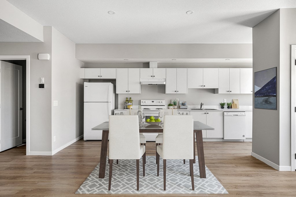 a kitchen and dining room with white cabinets and a table and chairs