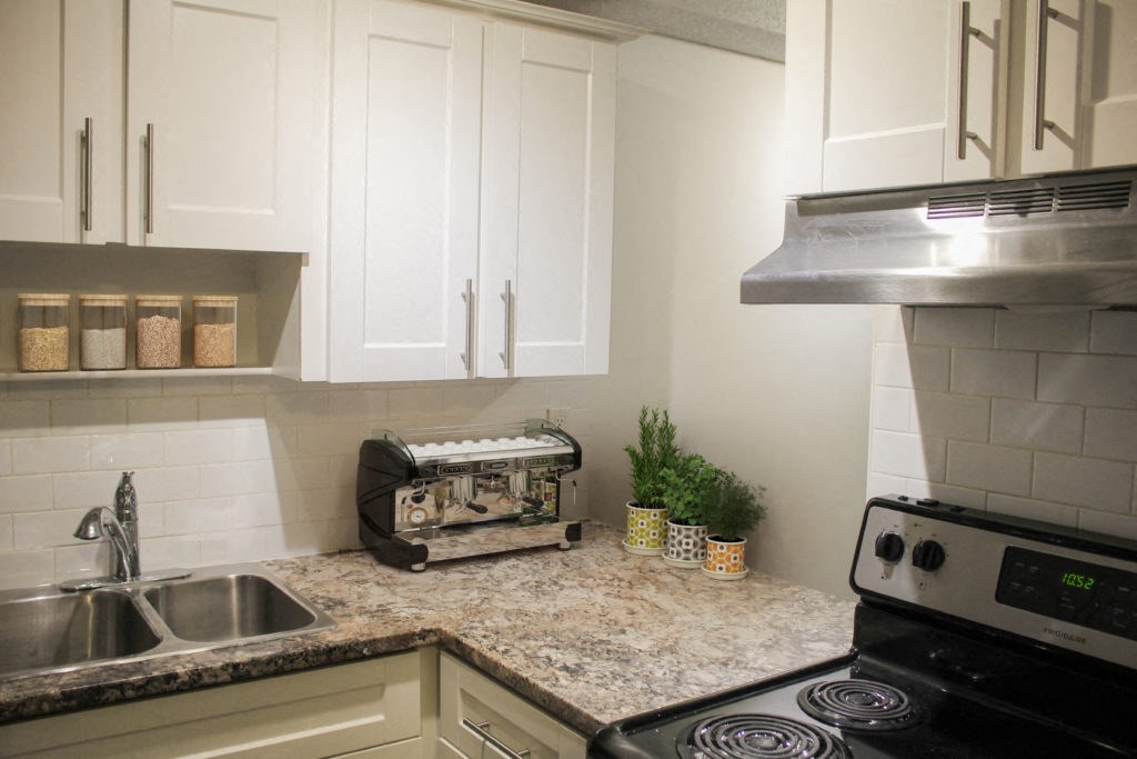 a kitchen with white cabinets and granite countertops