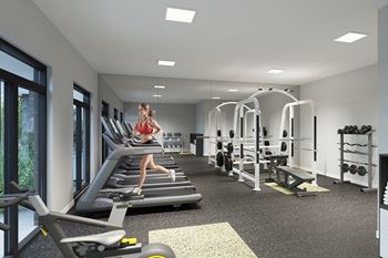 A woman is running on a treadmill in a well-equipped gym.