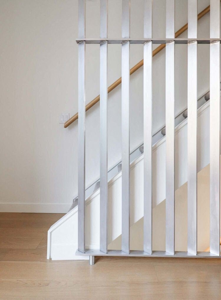 a white staircase with wooden railings in a home