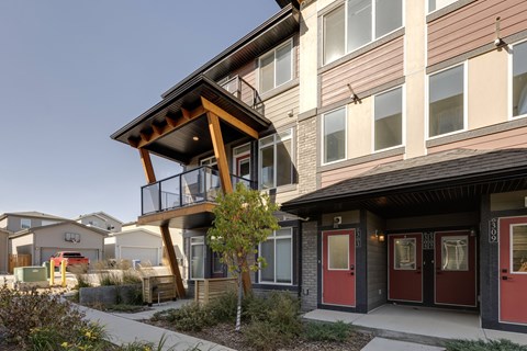 A modern house with a balcony and red doors.