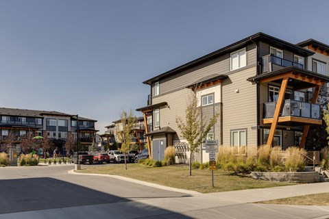 A modern two-story apartment building with a balcony on the second floor.