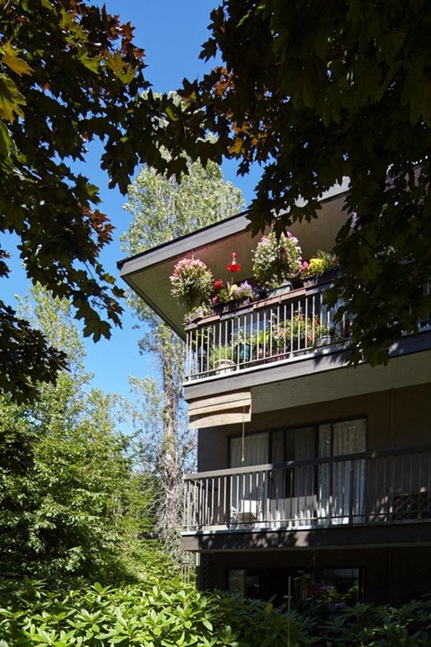 an apartment building with a balcony full of flowers