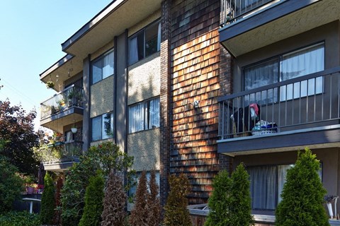 an apartment building with a dog on a balcony