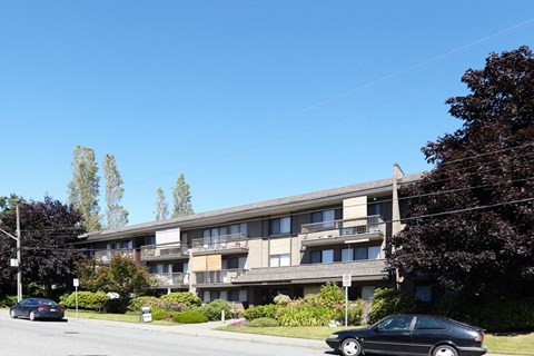 a large apartment building with cars parked in front of it