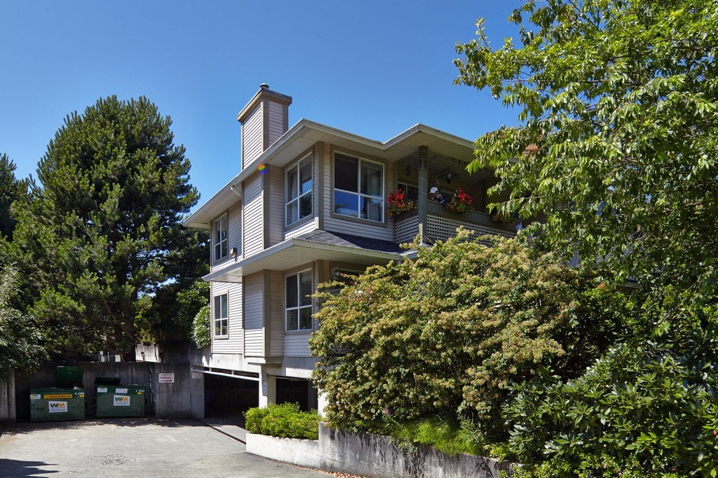 a house with a large garage and trees in front of it