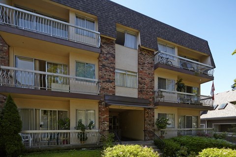 a view of an apartment building with balconies and a yard