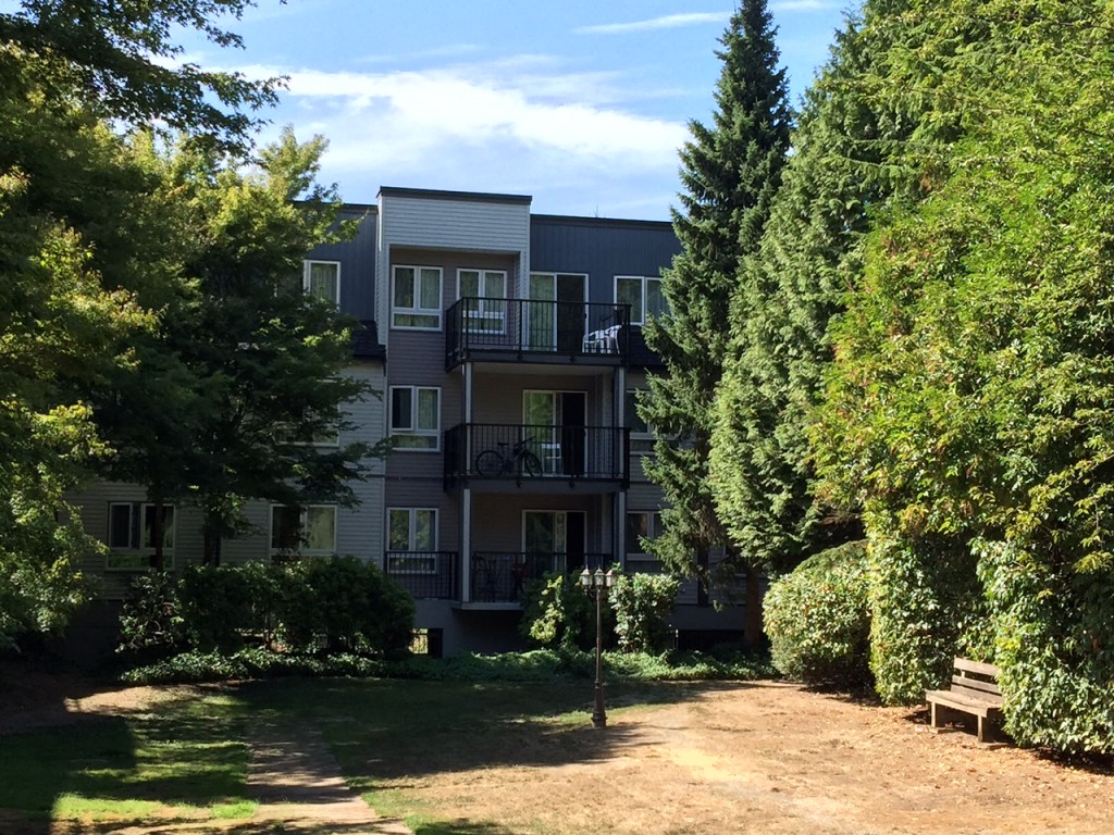 an apartment building with a park in front of it