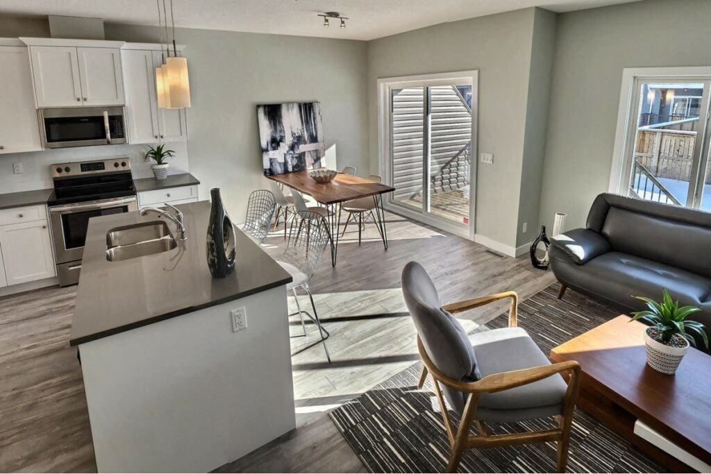 a kitchen and living room with a sliding glass door to a balcony
