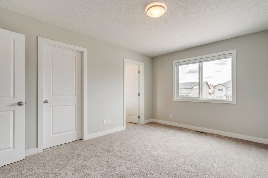 a bedroom with two doors and a window