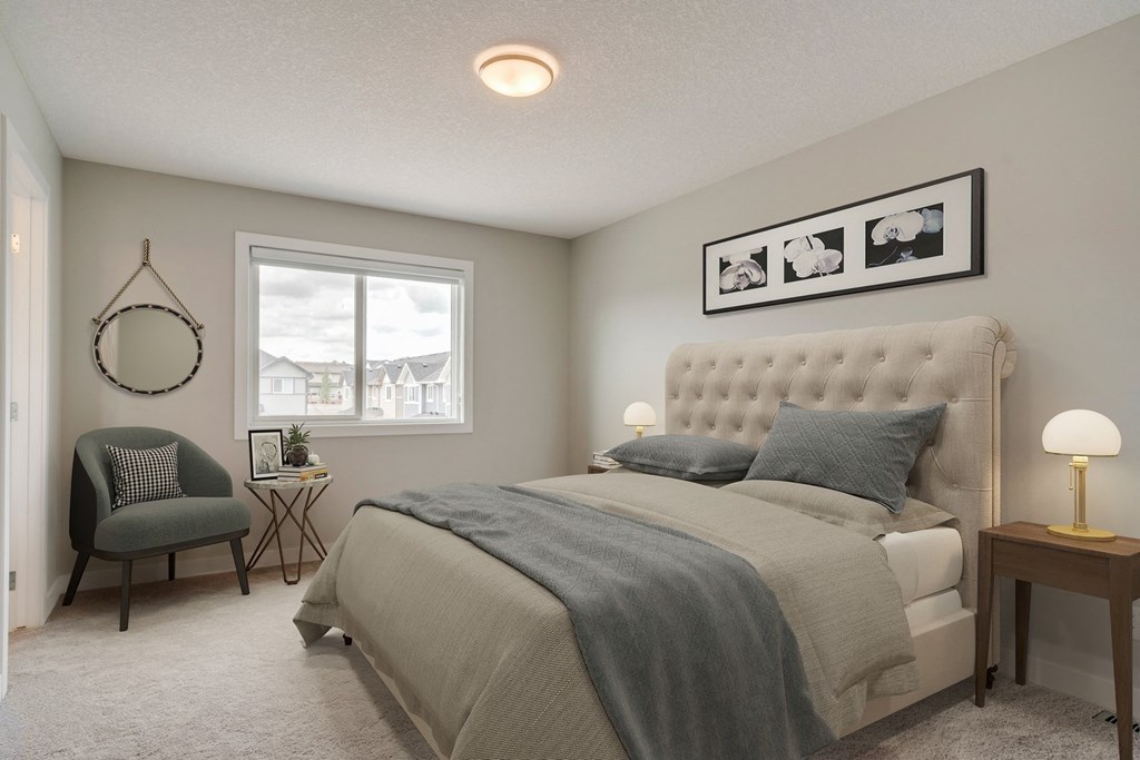 a bedroom with a bed and a chair and a window
