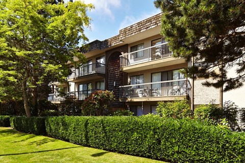 an apartment building with balconies and a manicured lawn