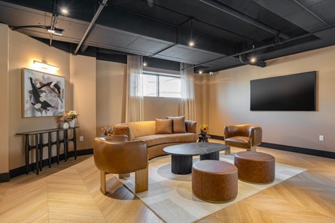 A modern living room with a large couch, a coffee table, and a TV mounted on the wall.