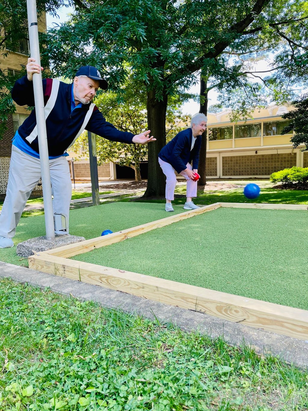 Two men playing mini golf in a grassy area.