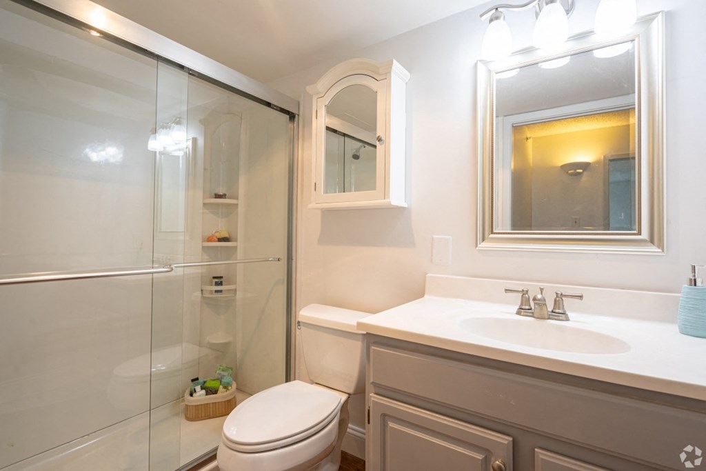 A white toilet sits in a bathroom next to a sink.