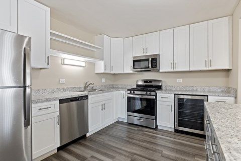 A kitchen with white cabinets and stainless steel appliances.
