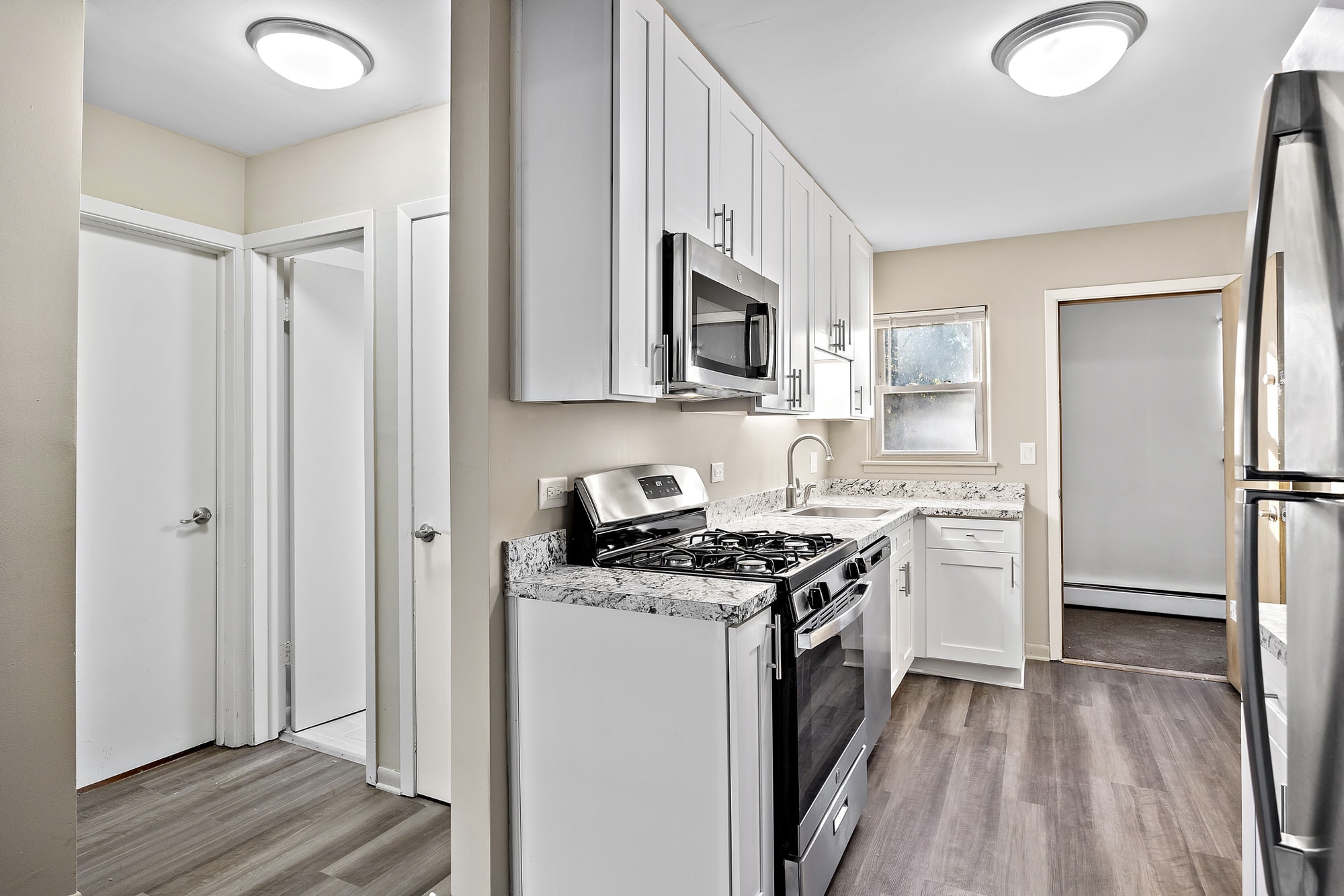 A kitchen with a stove top oven and a refrigerator.