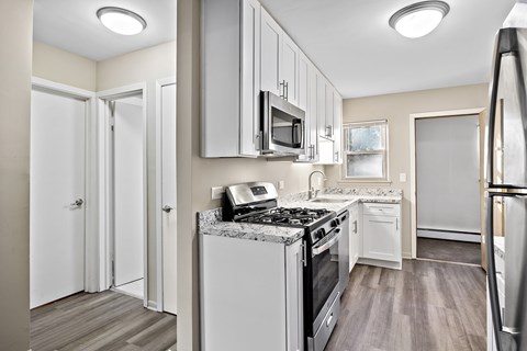 A kitchen with a stove top oven and a refrigerator.