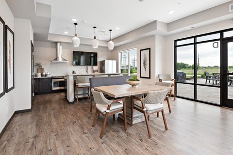 a dining room and kitchen area with a table and chairs