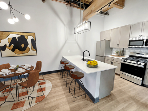 a kitchen with a large island and a table with chairs