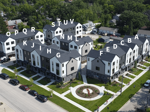 an aerial view of an apartment complex with white houses and gray roofs