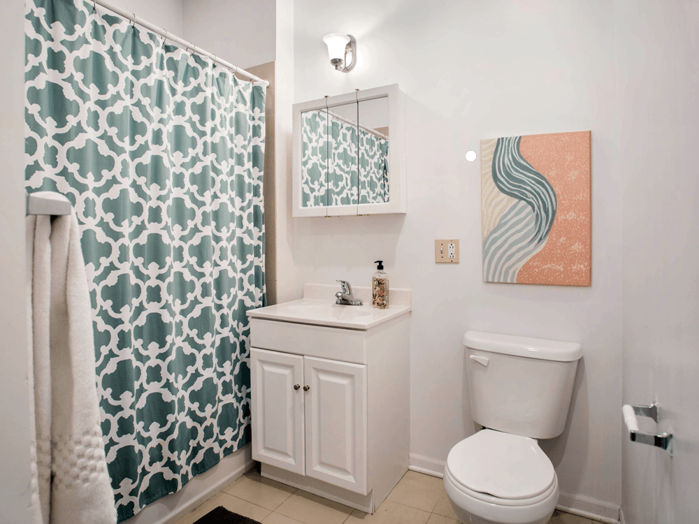 a bathroom with a shower and a toilet and a sink