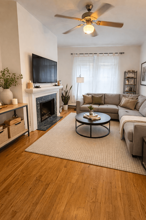 A living room with a fireplace, a couch, a coffee table, and a television.