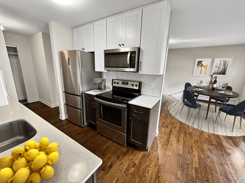 an open kitchen with stainless steel appliances and a dining room table