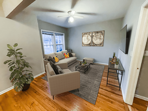 a living room with furniture and a ceiling fan