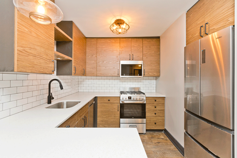 A modern kitchen with wooden cabinets and stainless steel appliances.