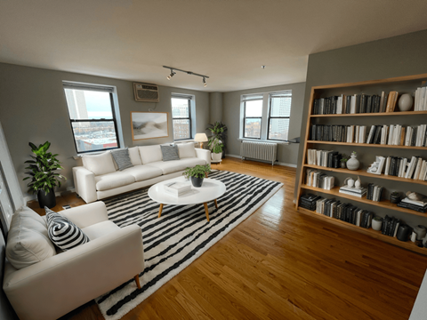 a living room with white furniture and a striped rug