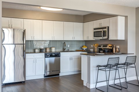 a kitchen with white cabinets and stainless steel appliances