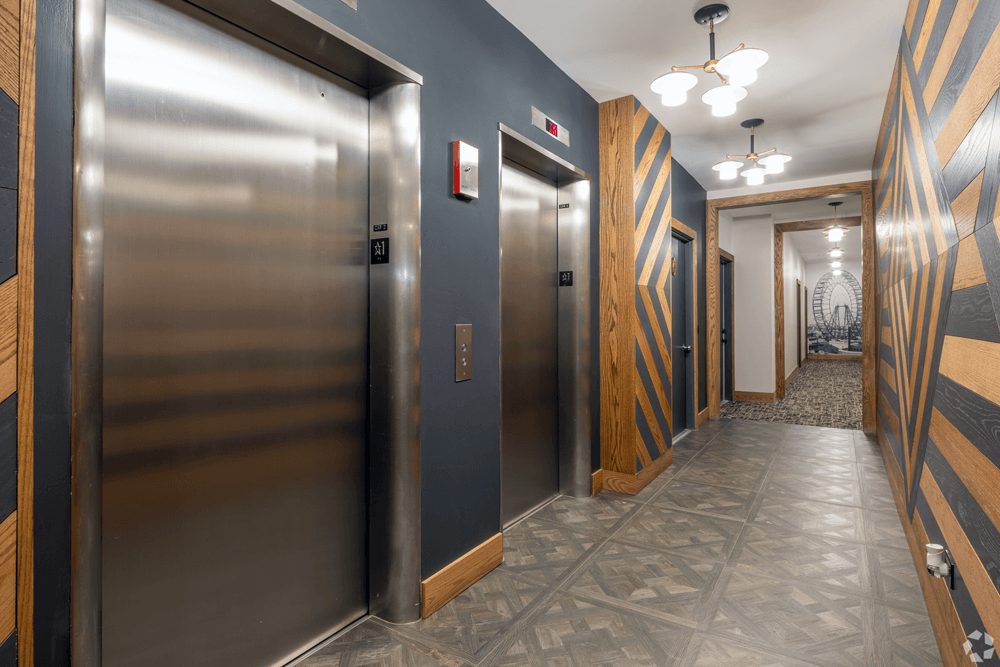 a hallway with stainless steel elevators and wooden doors at The Bryn - 5600 N Sheridan Rd Apartments, Illinois